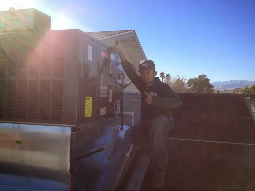 HVAC technician performing Heat Pump Repair on a rooftop unit in Denver
